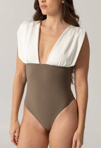 Woman wearing ARIEL one-piece swimsuit with deep V neckline and wide white shoulder detail paired with taupe fitted bottom, luxury swimwear for modest women.